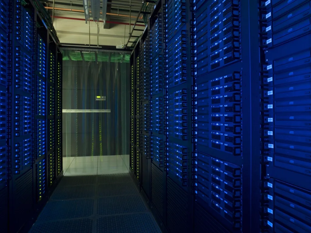 Rijen netwerkkabels langs een rek in een rekencentrum, netjes gebundeld.